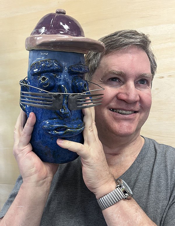 Richard Berkholtz holding a clay piece of art.