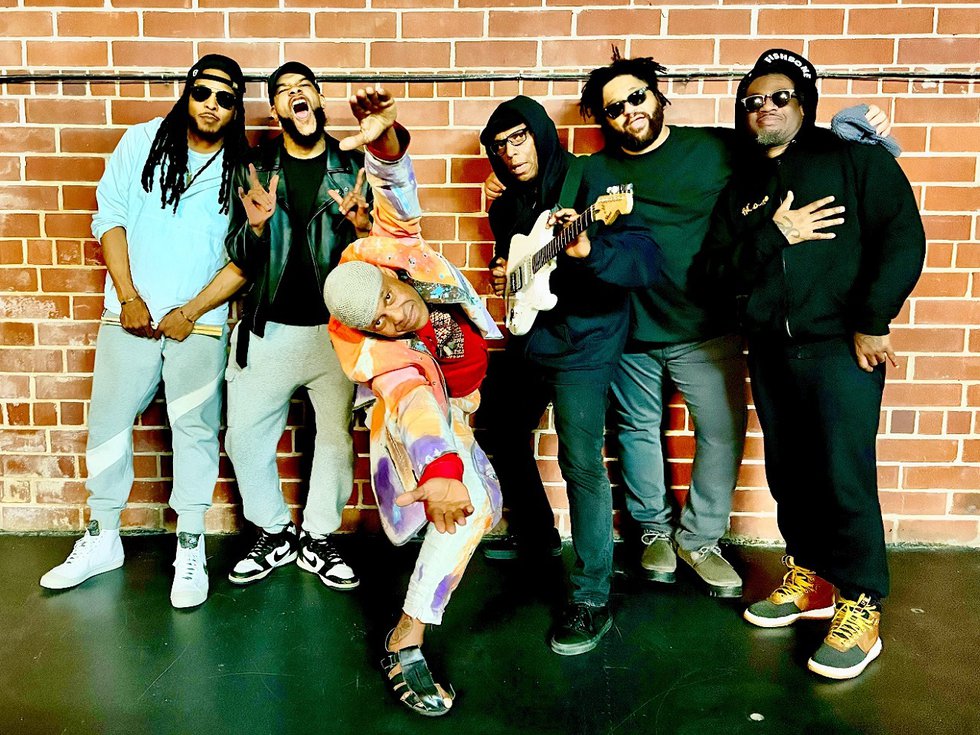 The band Fishbone in front of a brick wall.