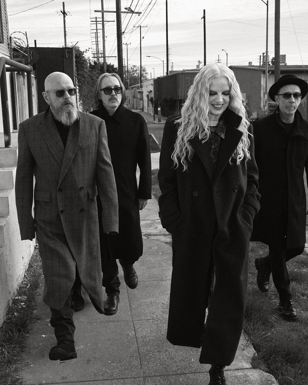The four members of Garbage on a sidewalk.
