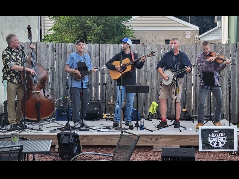 The five members of The Grazers on an outdoor stage.