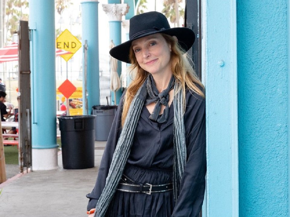 Eilen Jewell leaning on a blue wall.