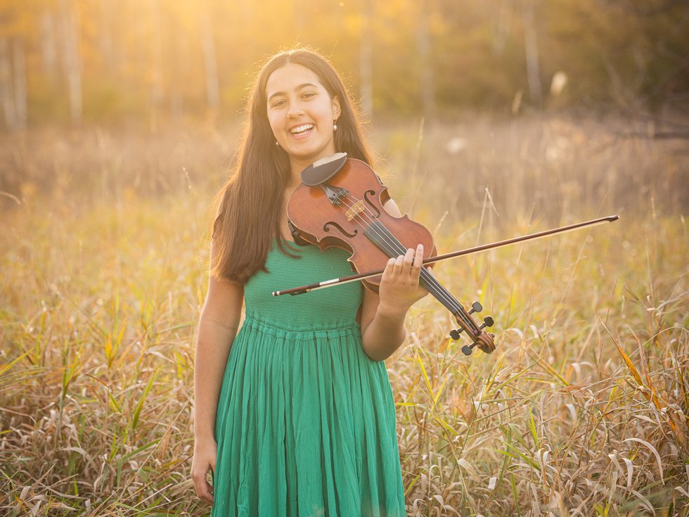 Indre Raghavan and violin in a field.