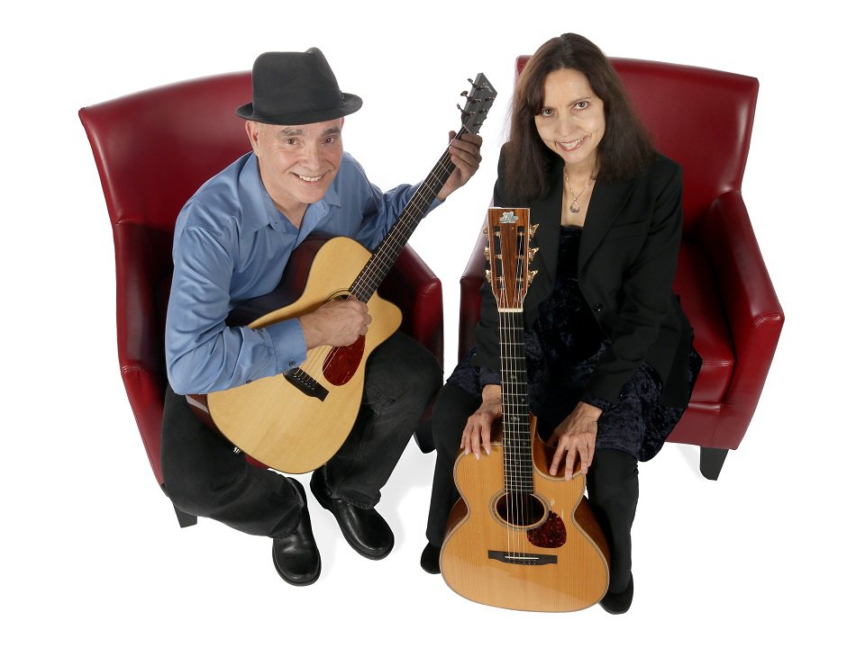 Red Door members Dave Irwin (left) and Helen Avakian with guitars on chairs.