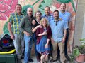 Seven-piece band The Whiskey Farm in front of a floral mural