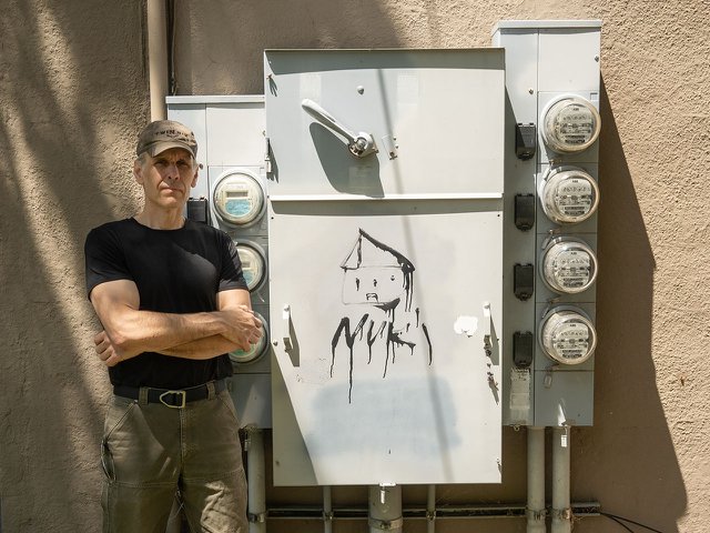Brad Hinkfuss next to an electrical meter.