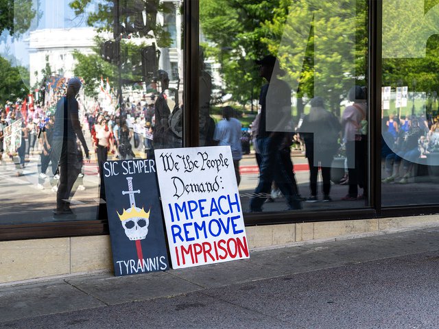 Protest signs leaning against the Veteran's Museum during the No Kings protest on June 14, 2025.